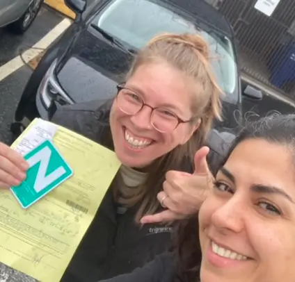 Driving Instructor with Happy Student Holding “N” Sign After Passing ICBC Road Test in Vancouver